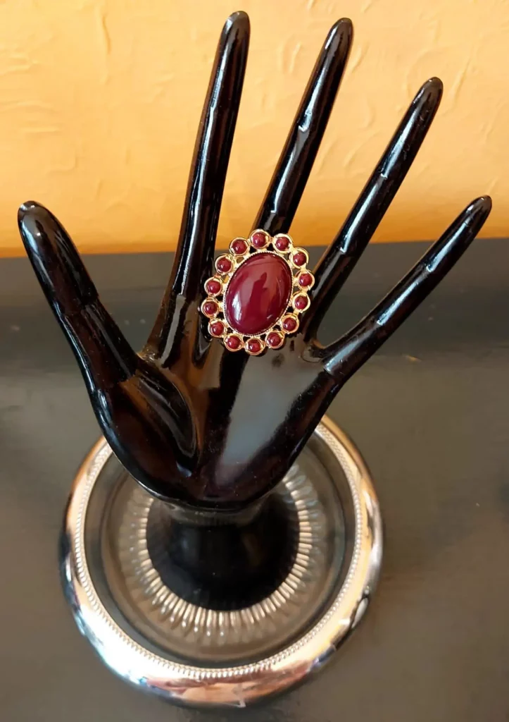 Exquisite large oval ‘ruby’ red stone, surrounded by smaller stones.